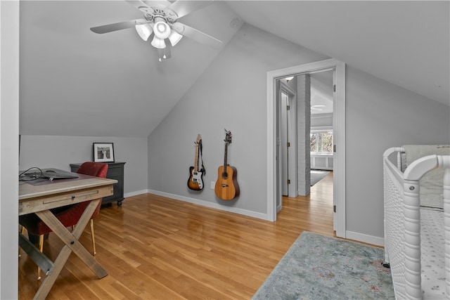 interior space featuring baseboards, ceiling fan, light wood-style flooring, and lofted ceiling