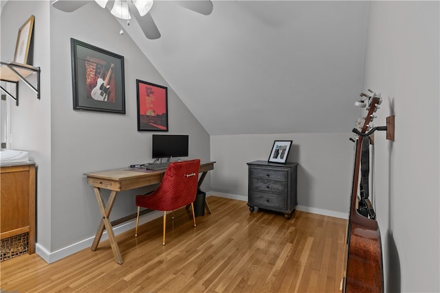 home office with ceiling fan, vaulted ceiling, baseboards, and light wood-type flooring