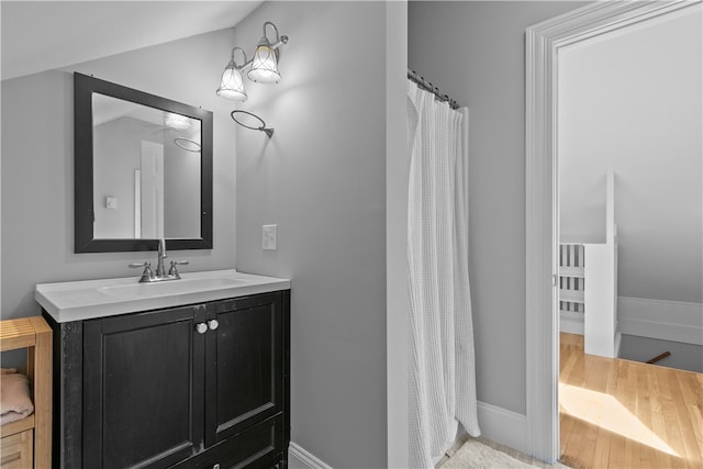 bathroom featuring vanity, baseboards, and wood finished floors