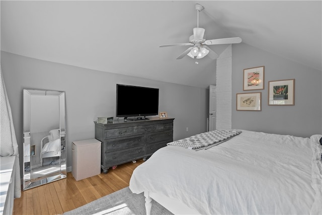 bedroom with a ceiling fan, wood finished floors, and lofted ceiling