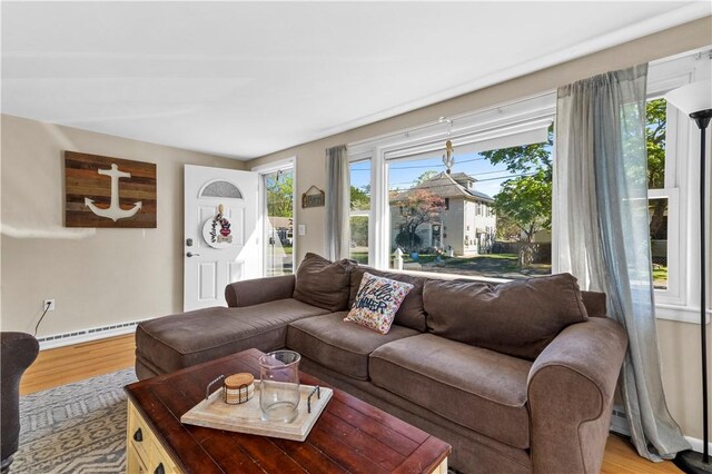 living room featuring light wood-style floors, baseboards, and baseboard heating