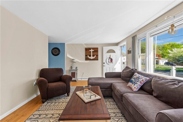 living area with baseboards, light wood-style flooring, and a baseboard radiator