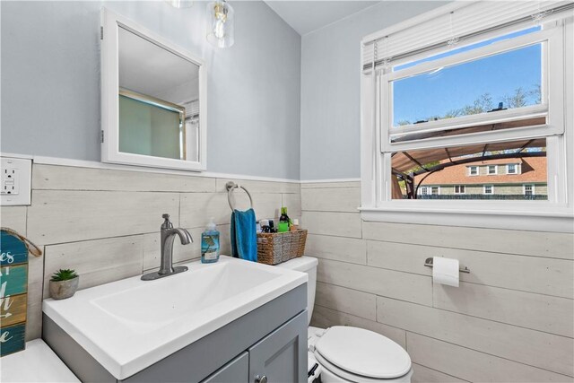 bathroom featuring vanity, wainscoting, and toilet