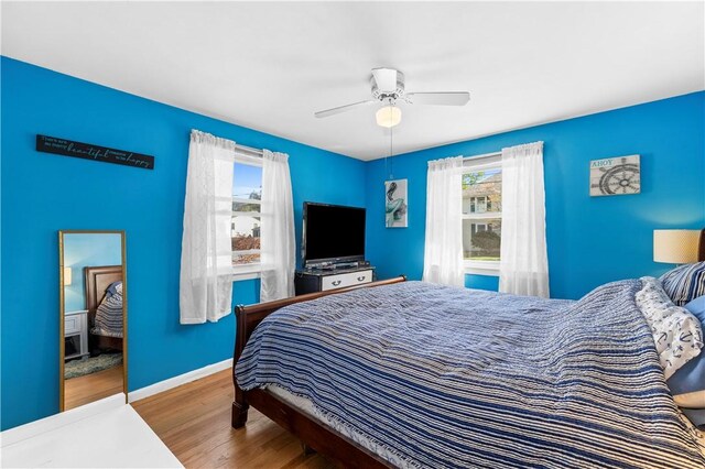 bedroom featuring baseboards, ceiling fan, and wood finished floors