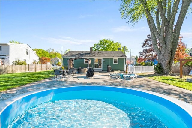 view of pool featuring a fenced backyard, a patio area, and a yard