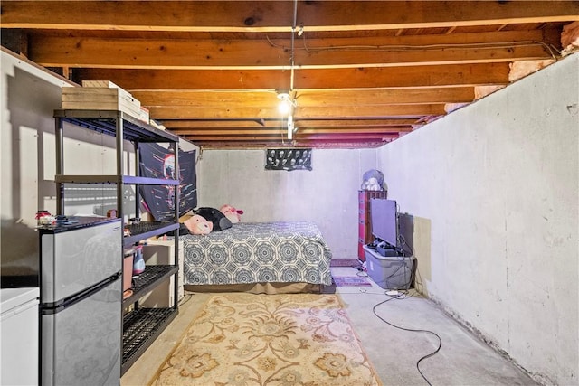 bedroom featuring freestanding refrigerator and concrete floors
