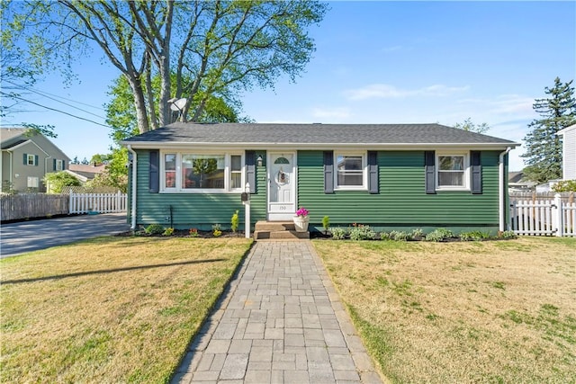 view of front of home featuring fence and a front lawn