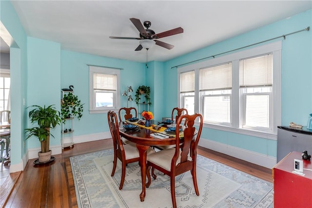 dining room with baseboards, light wood-style flooring, and ceiling fan