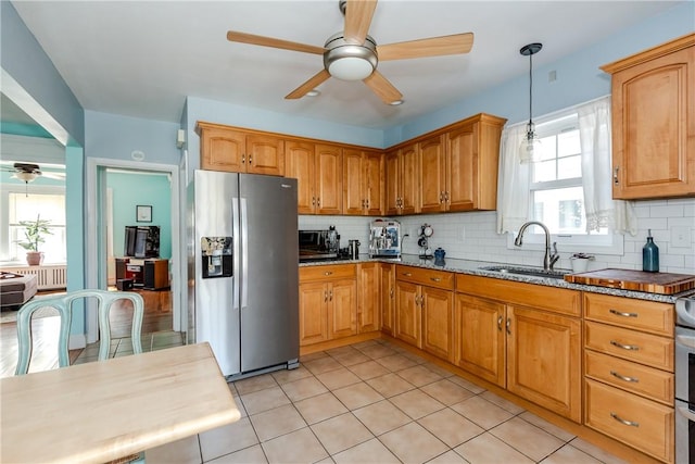 kitchen with backsplash, stainless steel refrigerator with ice dispenser, a ceiling fan, and a sink