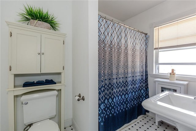 bathroom featuring toilet and a shower with shower curtain