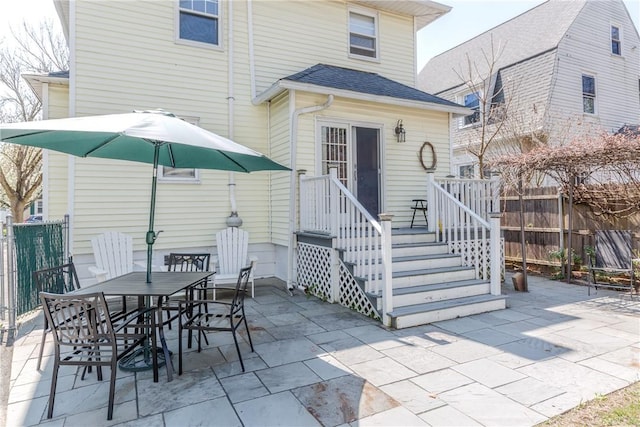 back of house featuring a patio, fence, outdoor dining space, and roof with shingles