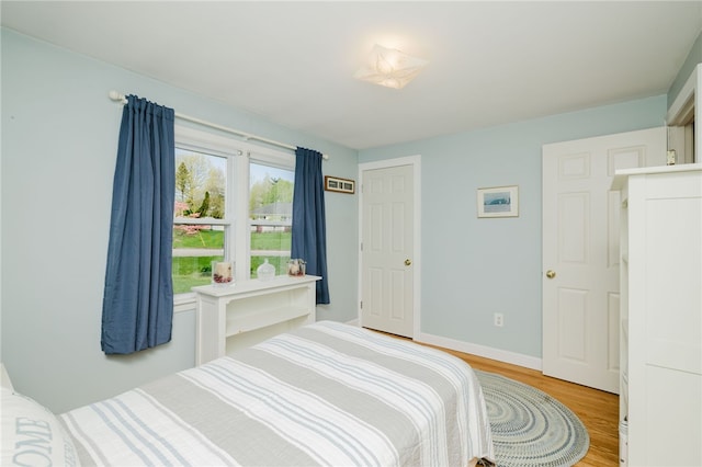 bedroom featuring baseboards and light wood finished floors