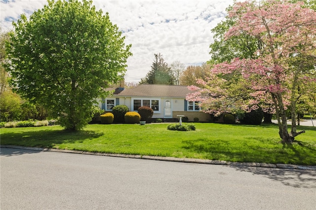 single story home with a chimney and a front yard