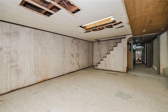 below grade area with wood walls, stairs, and tile patterned floors