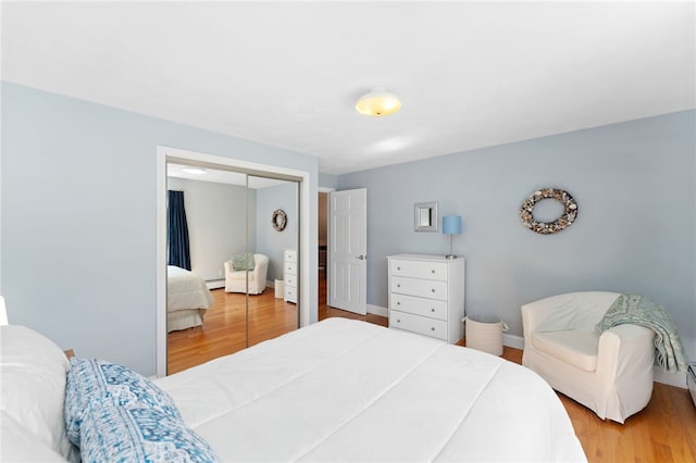 29 Howard Ave, Scituate, RI 02831 - bedroom featuring a closet, baseboards, wood finished floors, and baseboard heating
