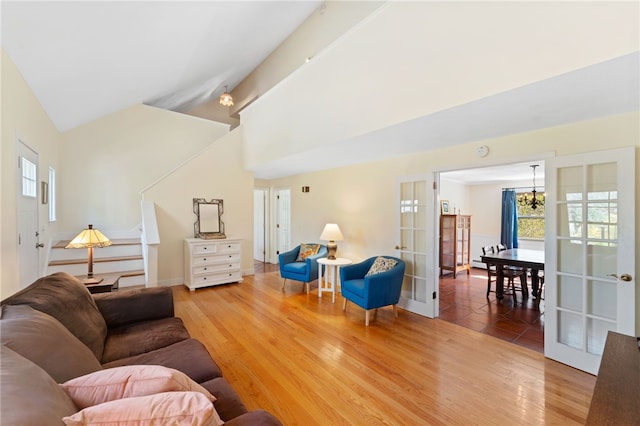 29 Howard Ave, Scituate, RI 02831 - living room with high vaulted ceiling, french doors, stairs, baseboards, and wood finished floors