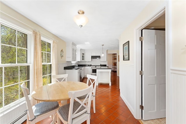 29 Howard Ave, Scituate, RI 02831 - dining space featuring dark tile patterned floors, wainscoting, and a decorative wall