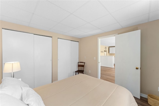 29 Howard Ave, Scituate, RI 02831 - bedroom featuring two closets, baseboards, a paneled ceiling, and wood finished floors