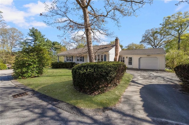 view of front facade with a garage, a front lawn, aphalt driveway, and a chimney