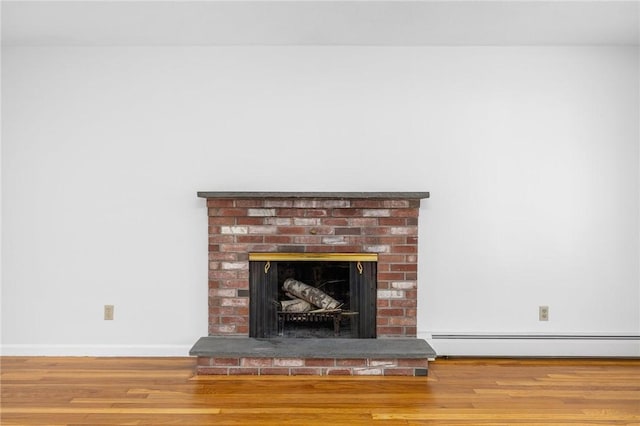 interior details with a fireplace, baseboards, baseboard heating, and wood finished floors