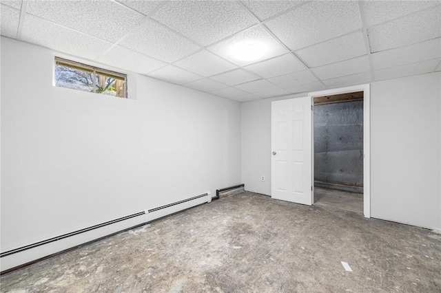 basement with a baseboard heating unit and a paneled ceiling