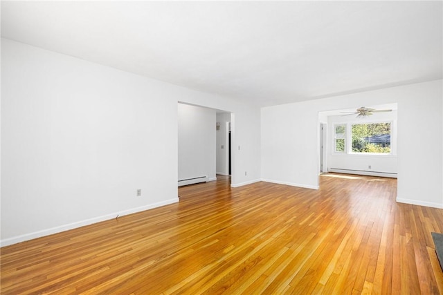 spare room with light wood-style floors, a baseboard radiator, baseboards, and ceiling fan