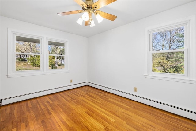 unfurnished room featuring a baseboard radiator, plenty of natural light, baseboard heating, and light wood-style floors
