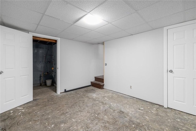 finished below grade area with a paneled ceiling and stairway