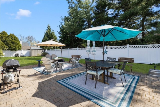 289 Oliphant Ln, Middletown, RI 02842 - view of patio / terrace with a storage unit, outdoor dining space, area for grilling, a fenced backyard, and an outbuilding