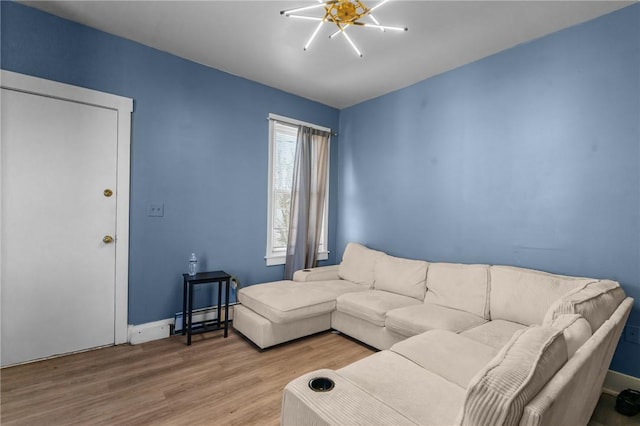 living area featuring baseboards, wood finished floors, and baseboard heating