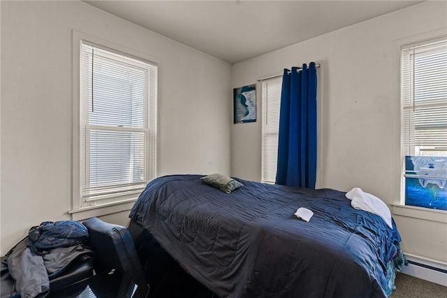 carpeted bedroom featuring a baseboard heating unit