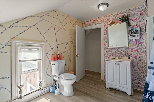bathroom with vanity, wood finished floors, and wallpapered walls