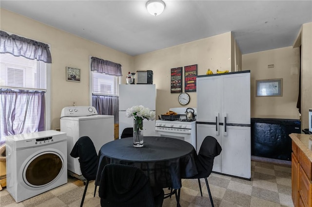 clothes washing area featuring light floors, laundry area, and washer / clothes dryer
