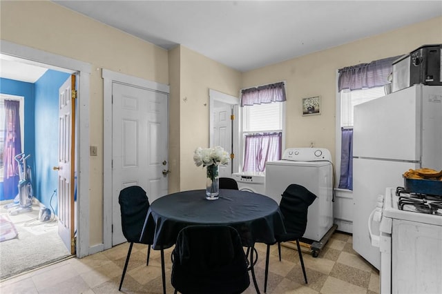 dining room with washer / dryer, light floors, and baseboard heating
