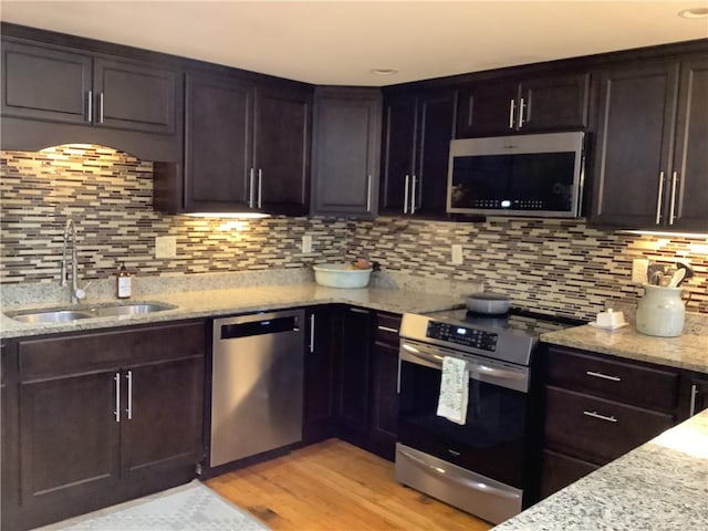 1 Tupperware Dr Unit 233, North Smithfield, RI 02896 - kitchen with stainless steel appliances, a sink, decorative backsplash, and light stone counters