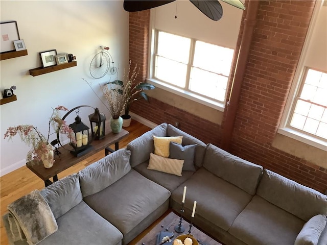 1 Tupperware Dr Unit 233, North Smithfield, RI 02896 - living area featuring wood finished floors, baseboards, brick wall, and a ceiling fan
