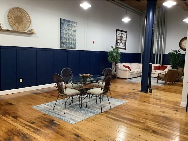 1 Tupperware Dr Unit 233, North Smithfield, RI 02896 - dining space with wood-type flooring, a decorative wall, and wainscoting