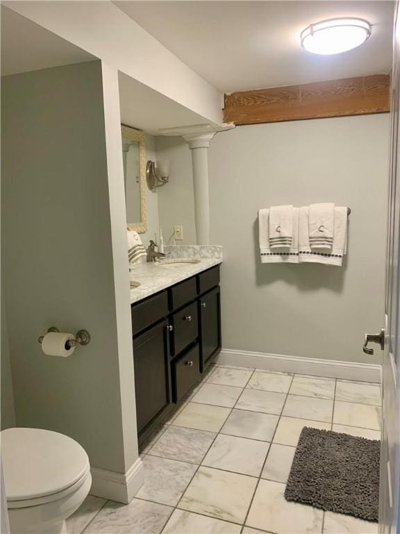 1 Tupperware Dr Unit 233, North Smithfield, RI 02896 - bathroom with marble look tile flooring, vanity, toilet, baseboards, and decorative columns