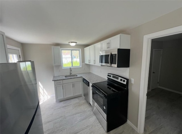 191 Canfield Ave, Warwick, RI 02889 - kitchen with appliances with stainless steel finishes, a sink, decorative backsplash, white cabinetry, and light stone countertops