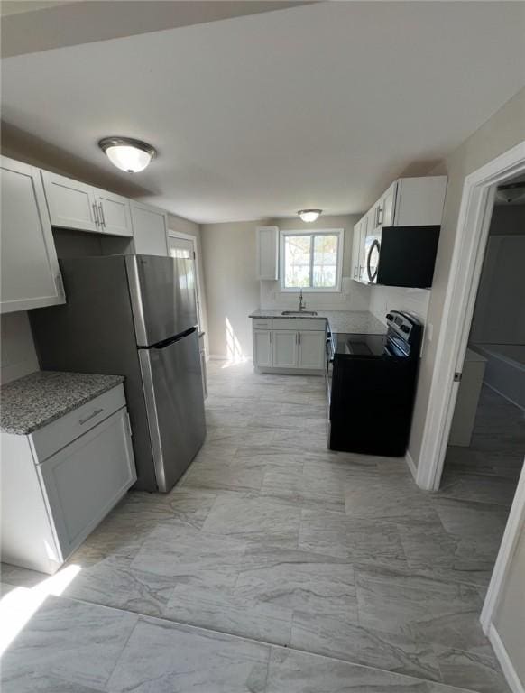 191 Canfield Ave, Warwick, RI 02889 - kitchen featuring stainless steel appliances, a sink, light marble finish floors, and white cabinets