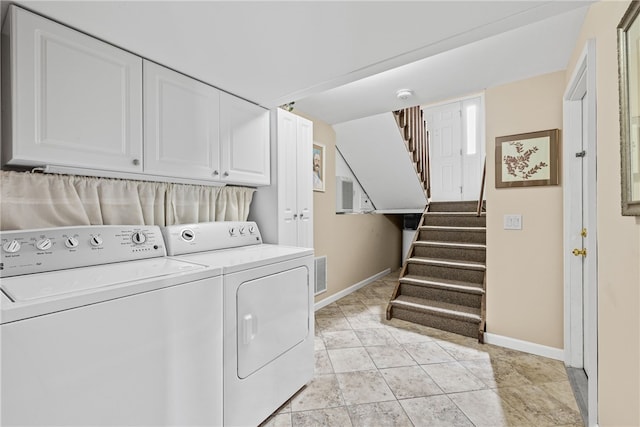 laundry area with baseboards, visible vents, cabinet space, and washer and dryer