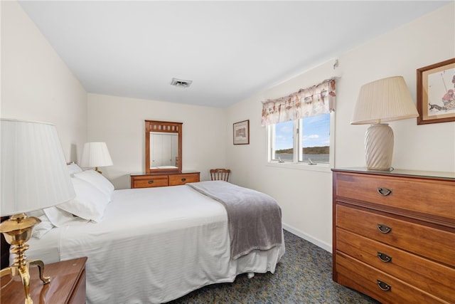 bedroom with baseboards, dark carpet, and visible vents