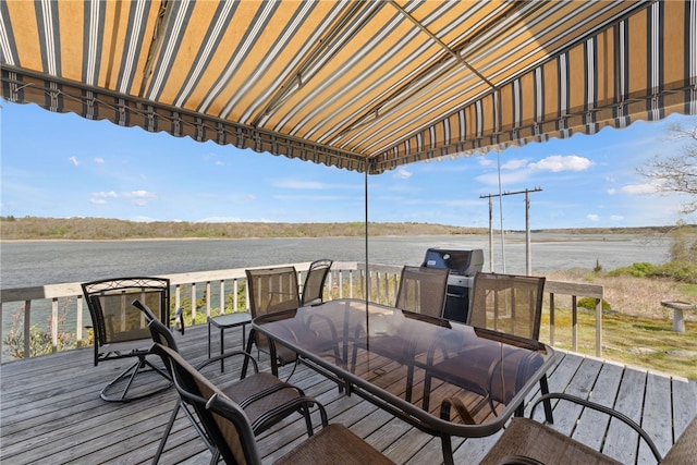 wooden deck featuring a water view and outdoor dining space