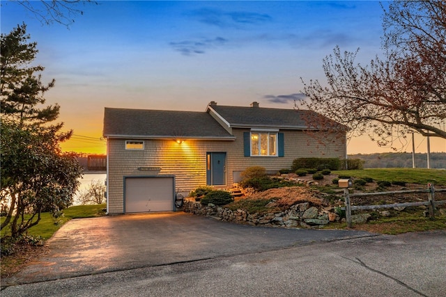 view of front of home featuring fence, an attached garage, driveway, and roof with shingles