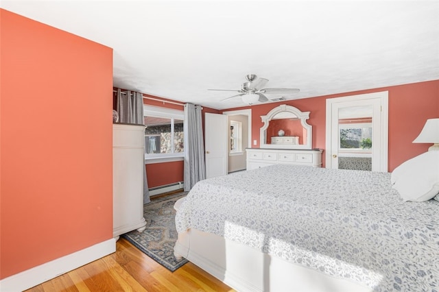 bedroom featuring baseboards, a baseboard radiator, a ceiling fan, and wood finished floors