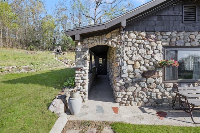 doorway to property with a yard and stone siding