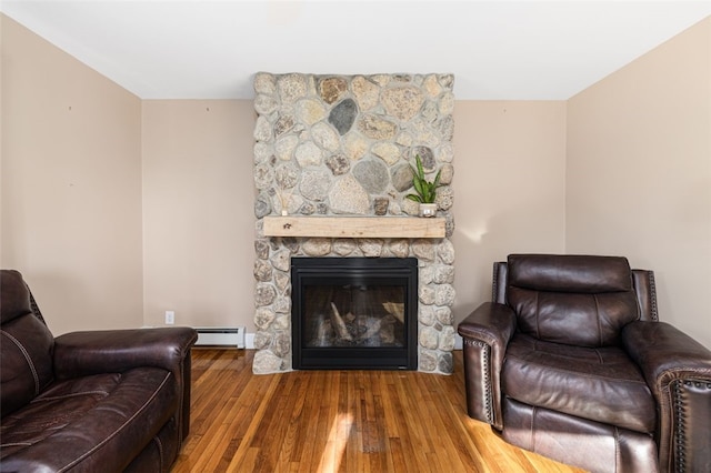 living room with baseboard heating, a fireplace, and wood finished floors