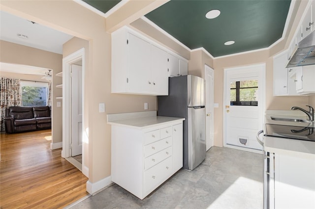kitchen featuring freestanding refrigerator, a wealth of natural light, a sink, and light countertops