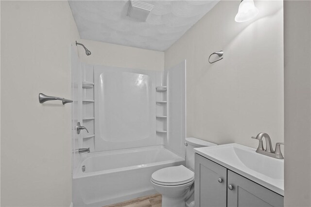 full bathroom featuring vanity, toilet, bathing tub / shower combination, wood finished floors, and visible vents