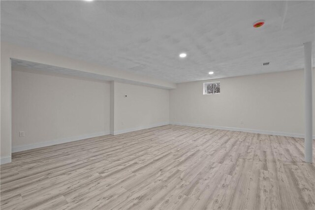 below grade area with recessed lighting, baseboards, and light wood-type flooring